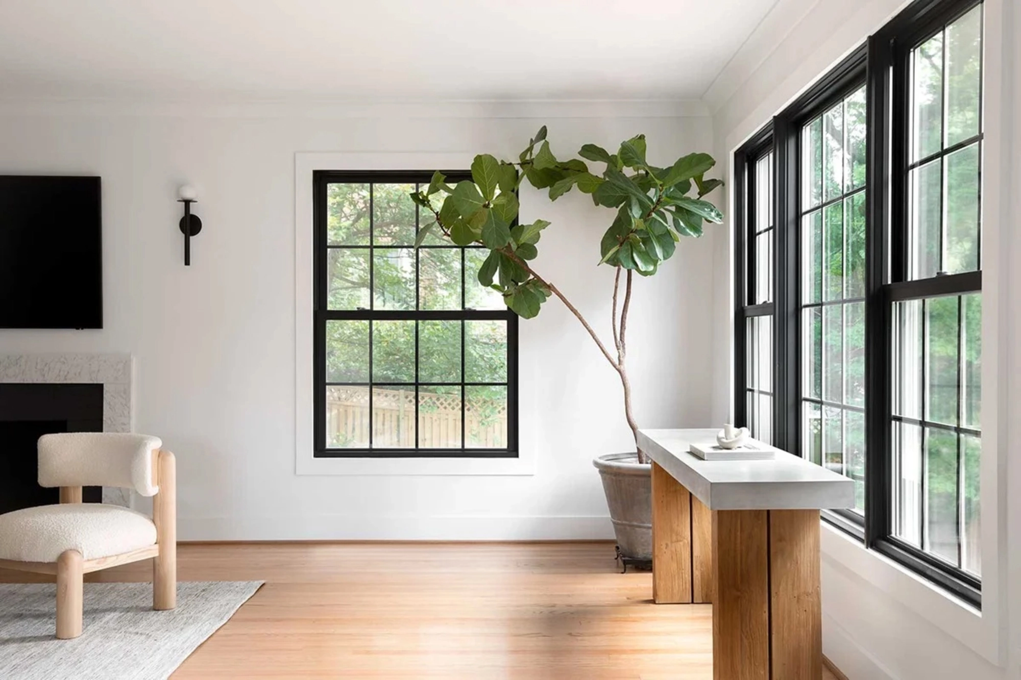 Modern living room with black-trimmed Marvin sound insulating windows, allowing natural light in while reducing outdoor noise for a quieter home