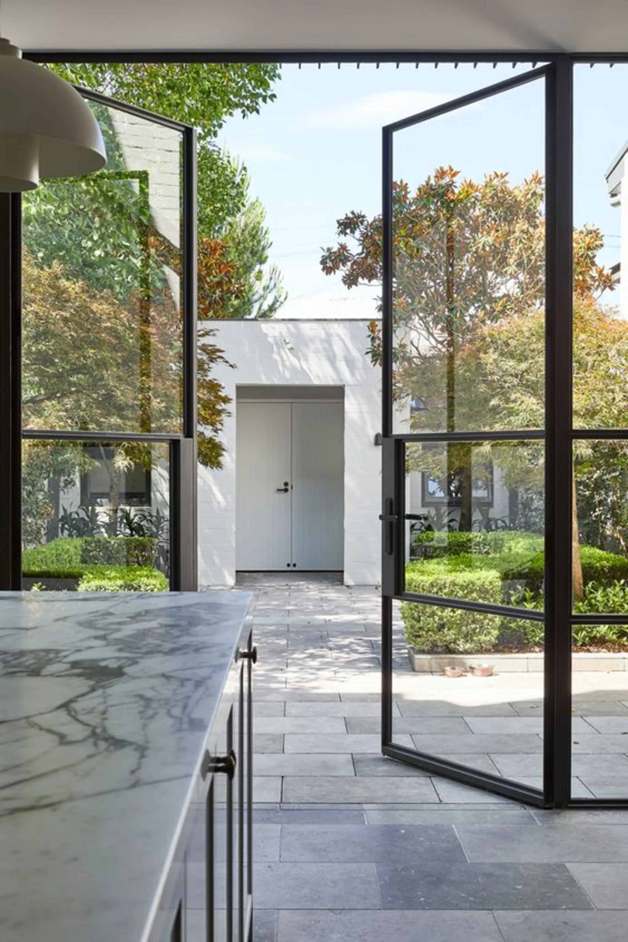 Modern patio view through sleek glass doors, highlighting clean lines and natural light, ideal for showcasing a steel vs fiberglass door comparison