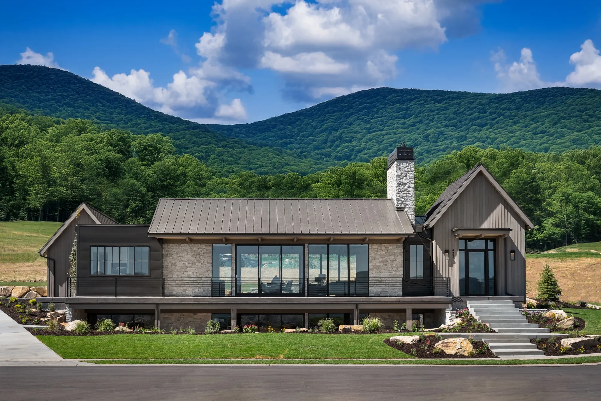 Contemporary home design featuring minimalist design principles with expansive black-framed windows and a clean modern exterior set against mountain views