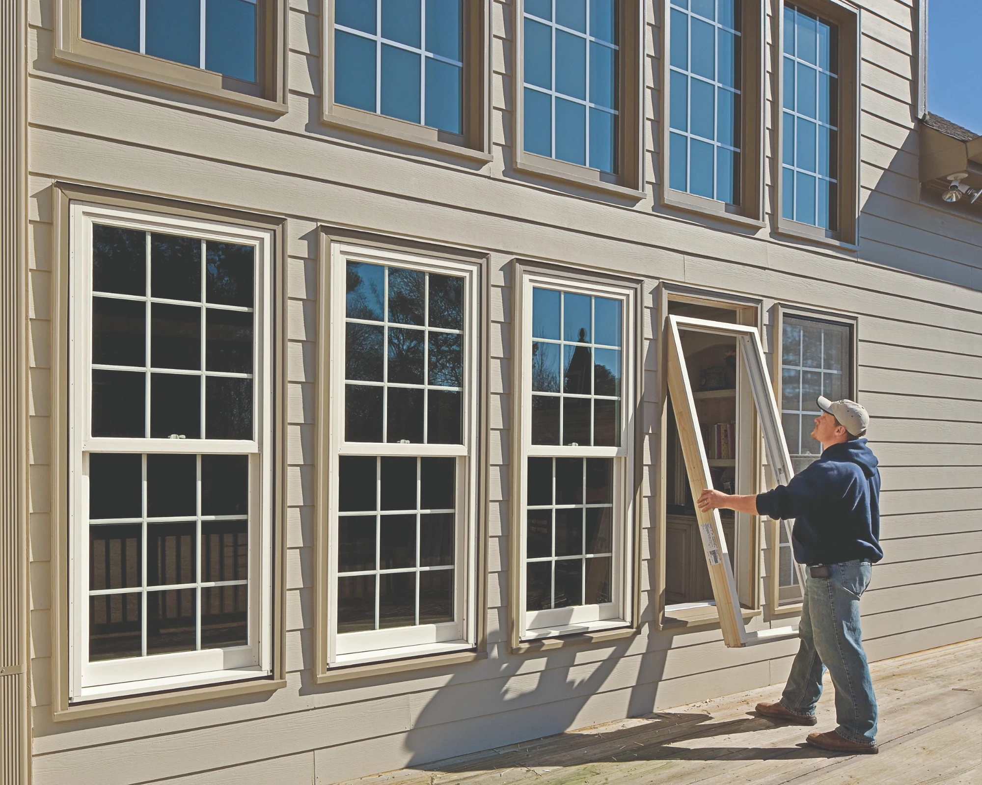 Double hung vs single hung windows installation showing a professional replacing a window on a two-story home