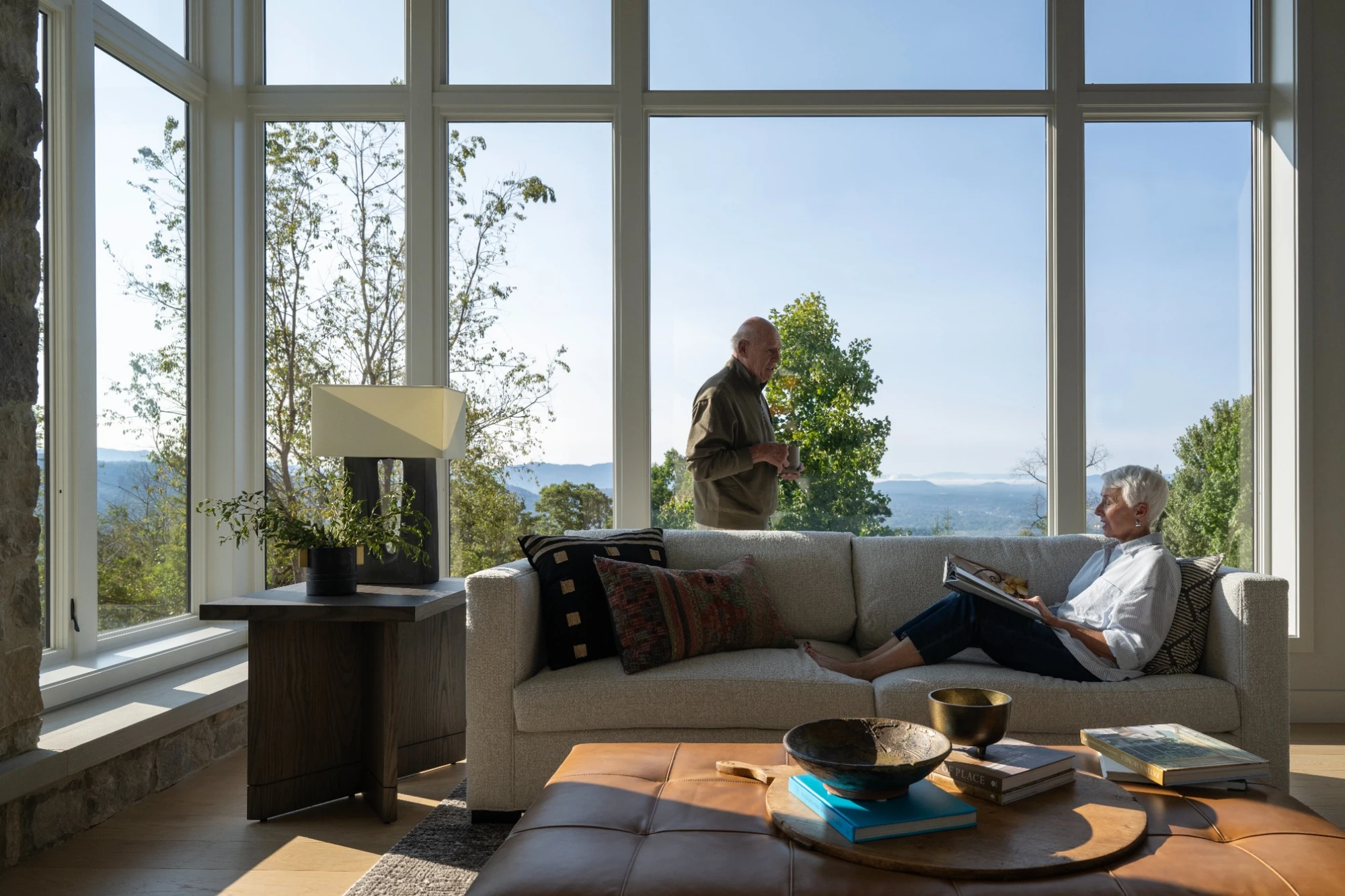 Floor to ceiling windows in a modern living room with expansive views, filling the space with natural light and highlighting an open, airy interior