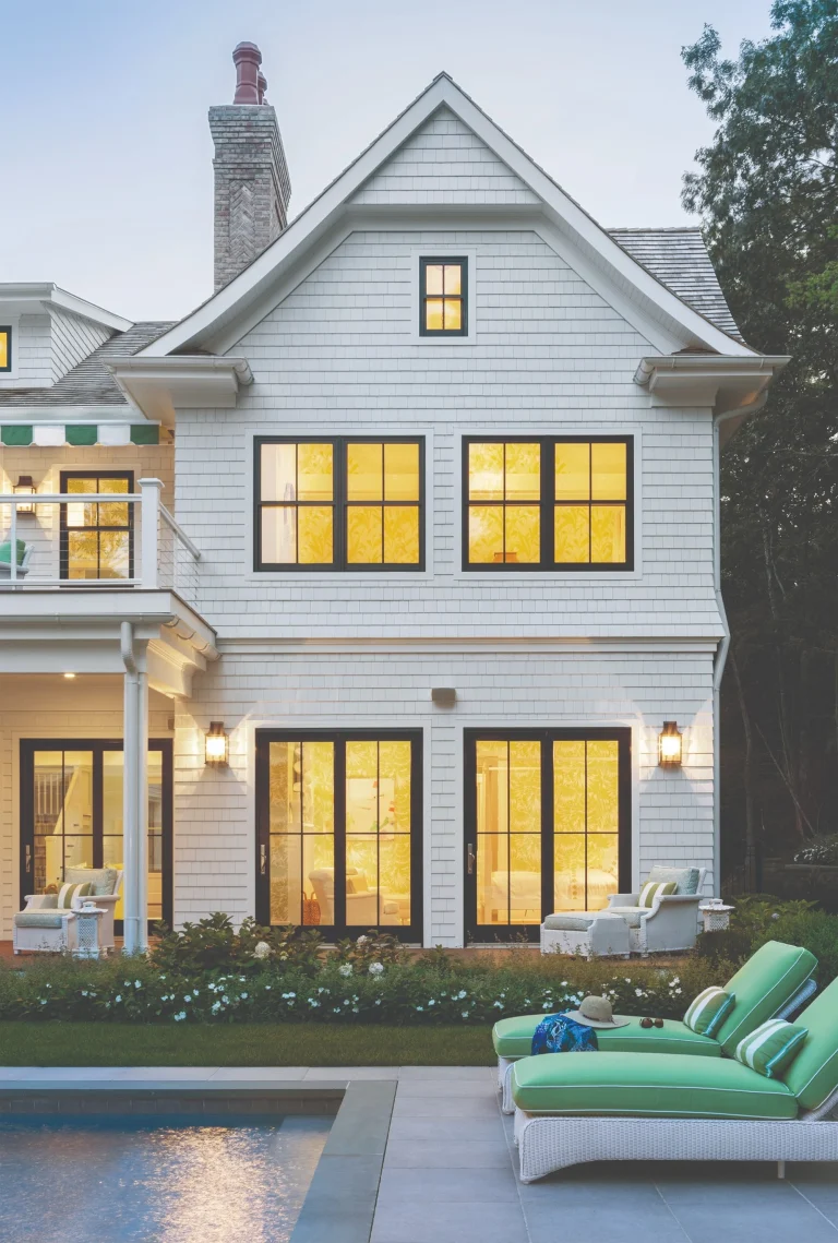 Best windows for traditional homes featuring classic double-hung windows on a coastal-style exterior with black frames and warm interior lighting