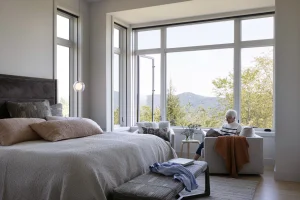 Best windows for traditional homes featuring classic double-hung windows on a coastal-style exterior with black frames and warm interior lighting