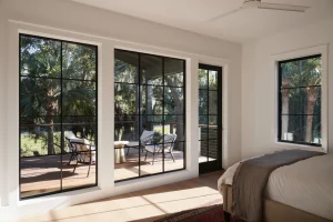 Best windows for traditional homes featuring classic double-hung windows on a coastal-style exterior with black frames and warm interior lighting