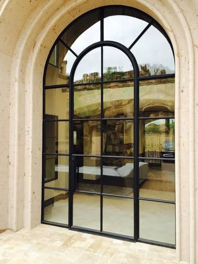 Luxury arched round windows with black steel frames set in a stone exterior, blending modern design with classic architecture