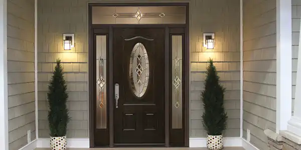 Image of fiberglass entry door with dark woodgrain finish and decorative glass sidelites on residential home