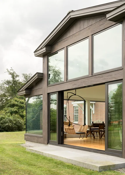 Image of modern home with sliding glass windows on modern wood-clad exterior