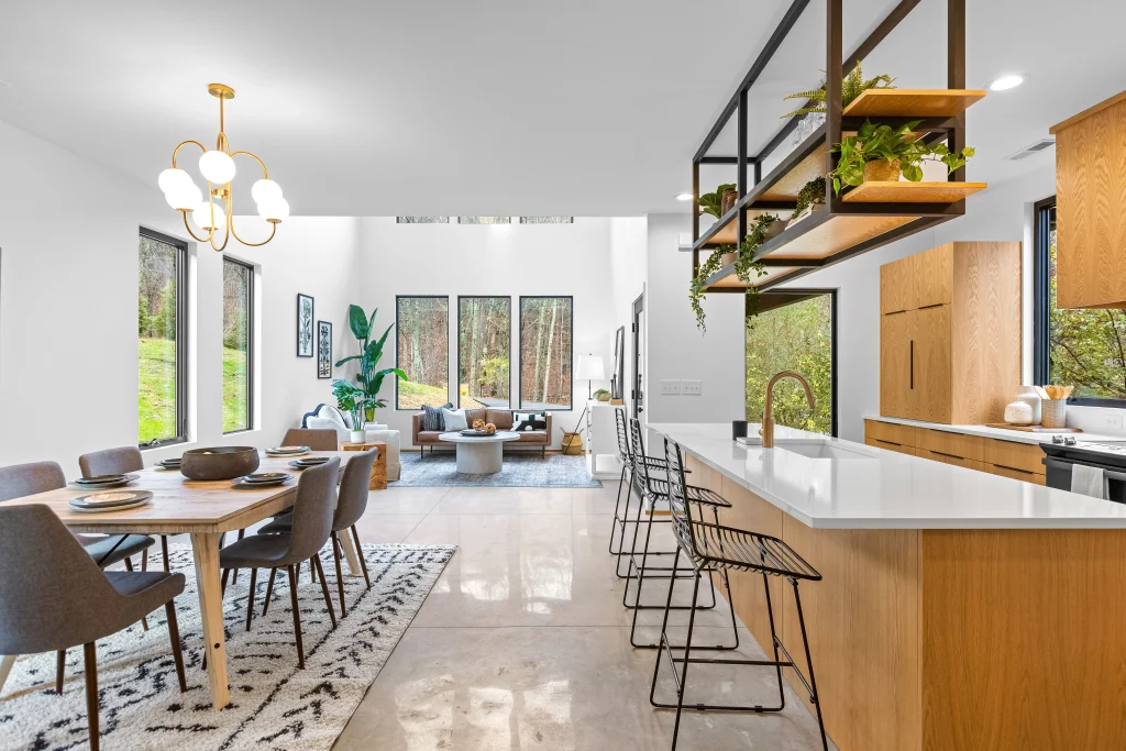 Image of Marvin Essential black casement frames in open-concept modern kitchen and living room. comparing wood vs. vinyl windows