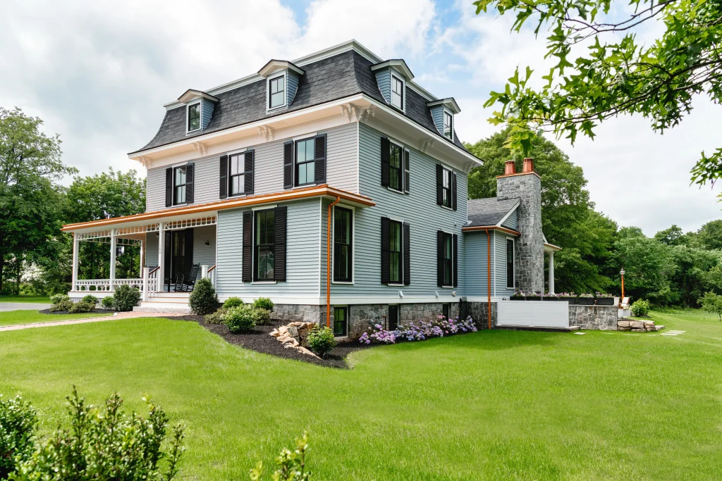 Image of Marvin Ultimate double-hung windows with black shutters on blue Victorian-style home exterior