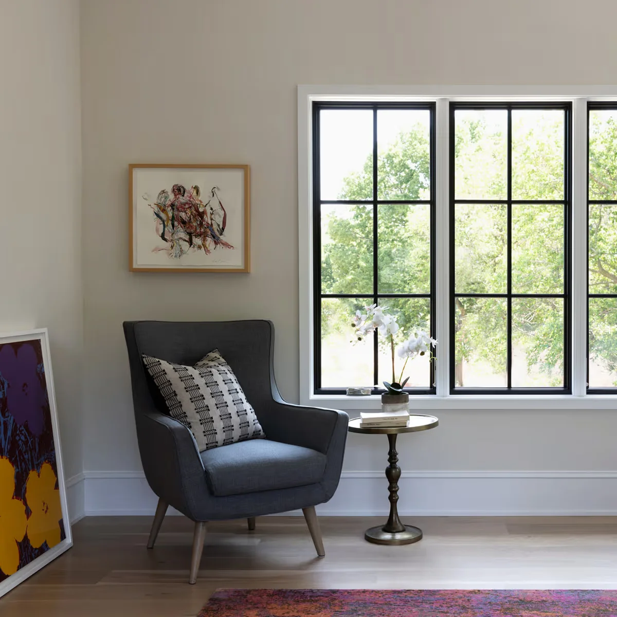 Image of a living room showcasing marvin windows benefits through elegant black-framed casement windows with natural light