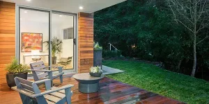image of modern vinyl patio doors leading to an outdoor deck with seating and landscaped yard
