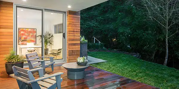 image of modern vinyl patio doors leading to an outdoor deck with seating and landscaped yard