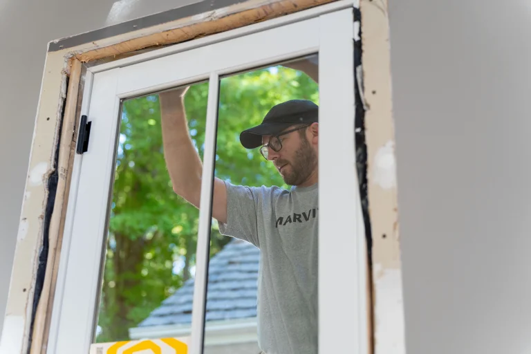 Image of a Marvin installer fitting a new window frame, showing the professional process of when to replace a front door