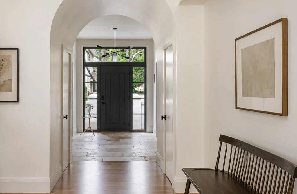 Image of a modern home entryway featuring a black front door with sidelights and transom window
