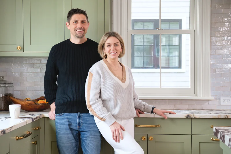 Image of a couple standing in their kitchen next to a newly installed replacement window