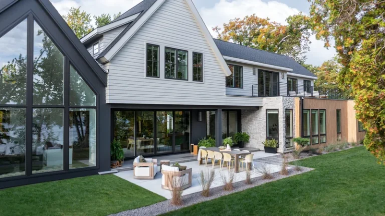 Image of a modern farmhouse exterior with floor-to-ceiling Marvin windows and mixed architectural window styles