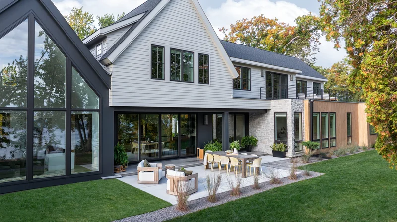 Image of a modern farmhouse exterior with floor-to-ceiling Marvin windows and mixed architectural window styles