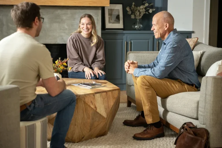 Image of how to choose a window replacement company with a consultant meeting with homeowners in their living room