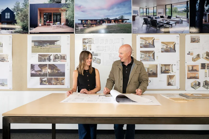 Image of a design consultation reviewing Marvin window plans and home renderings together