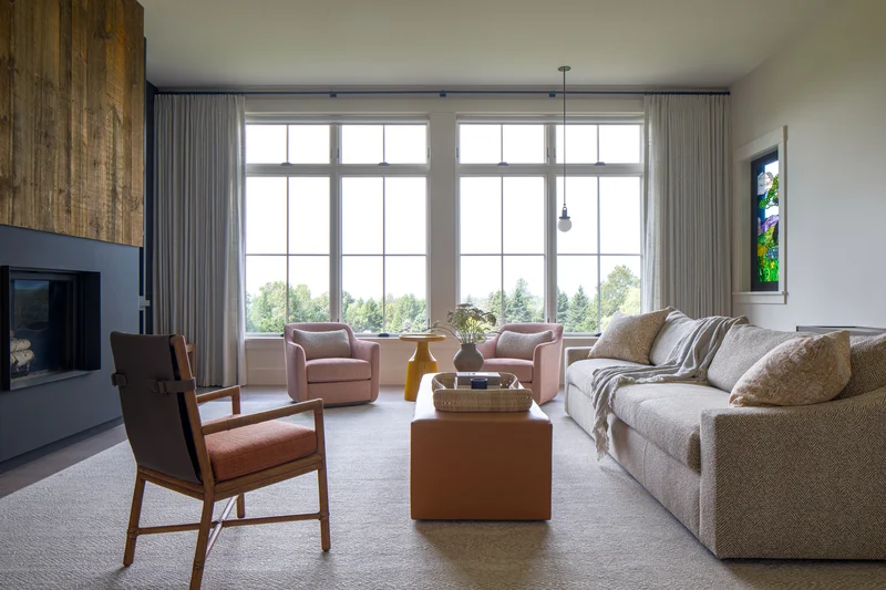 Image of a finished living room featuring large Marvin windows and natural light
