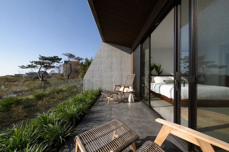 Image of a bedroom sliding glass door opening onto a coastal patio
