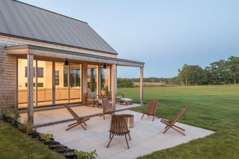 Image of a farmhouse sliding patio door open to an evening outdoor patio