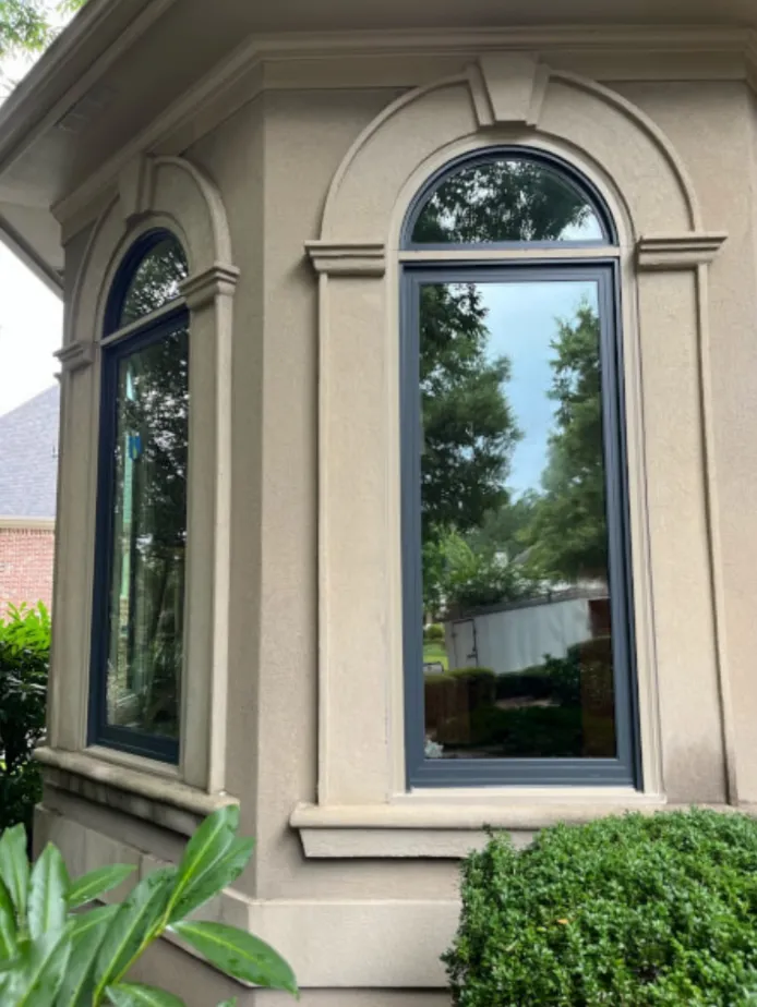 dark-framed arched replacement windows in Atlanta on a stucco home in Suwanee, GA